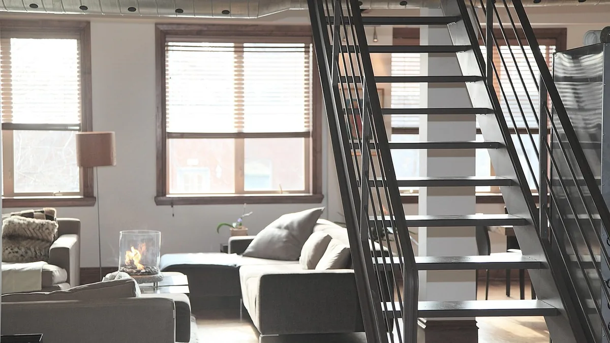 Escalier métallique noir de style industriel dans un séjour à grande fenêtre