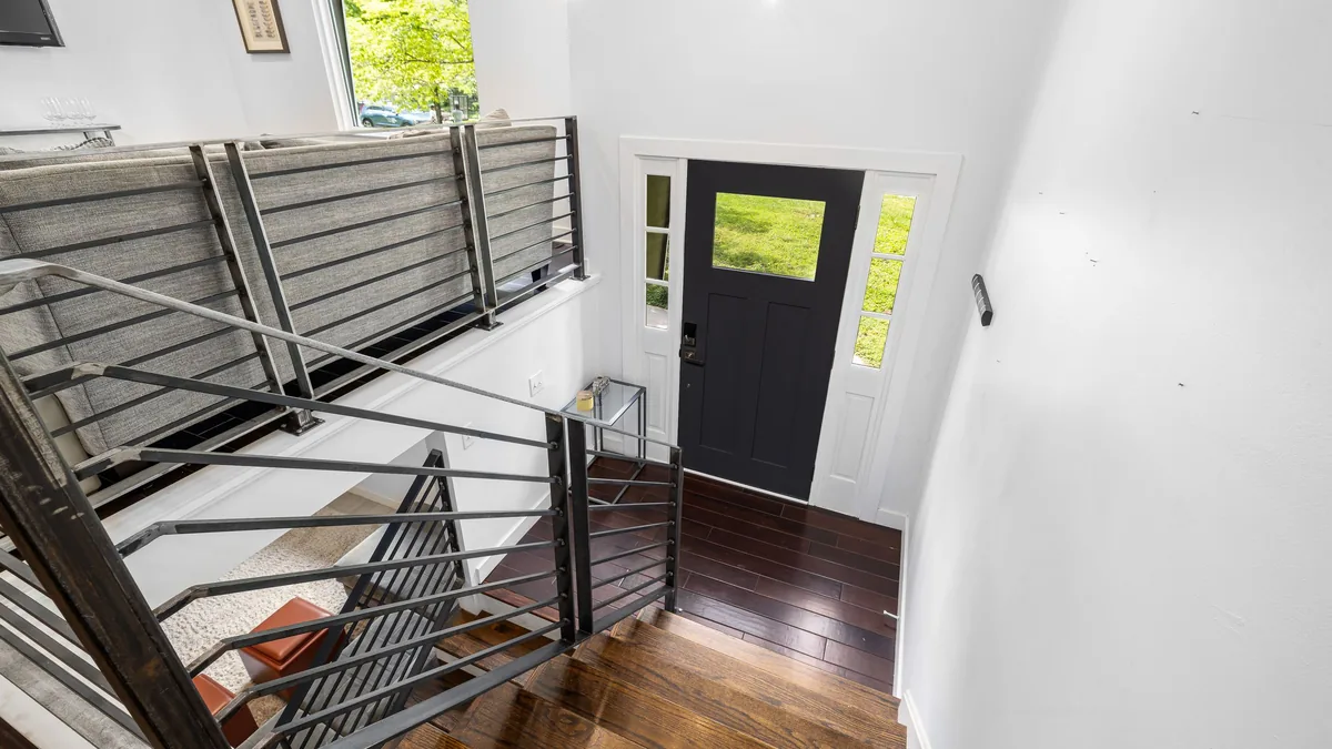 Garde-corps à lisses horizontales noires le long d'un escalier en bois