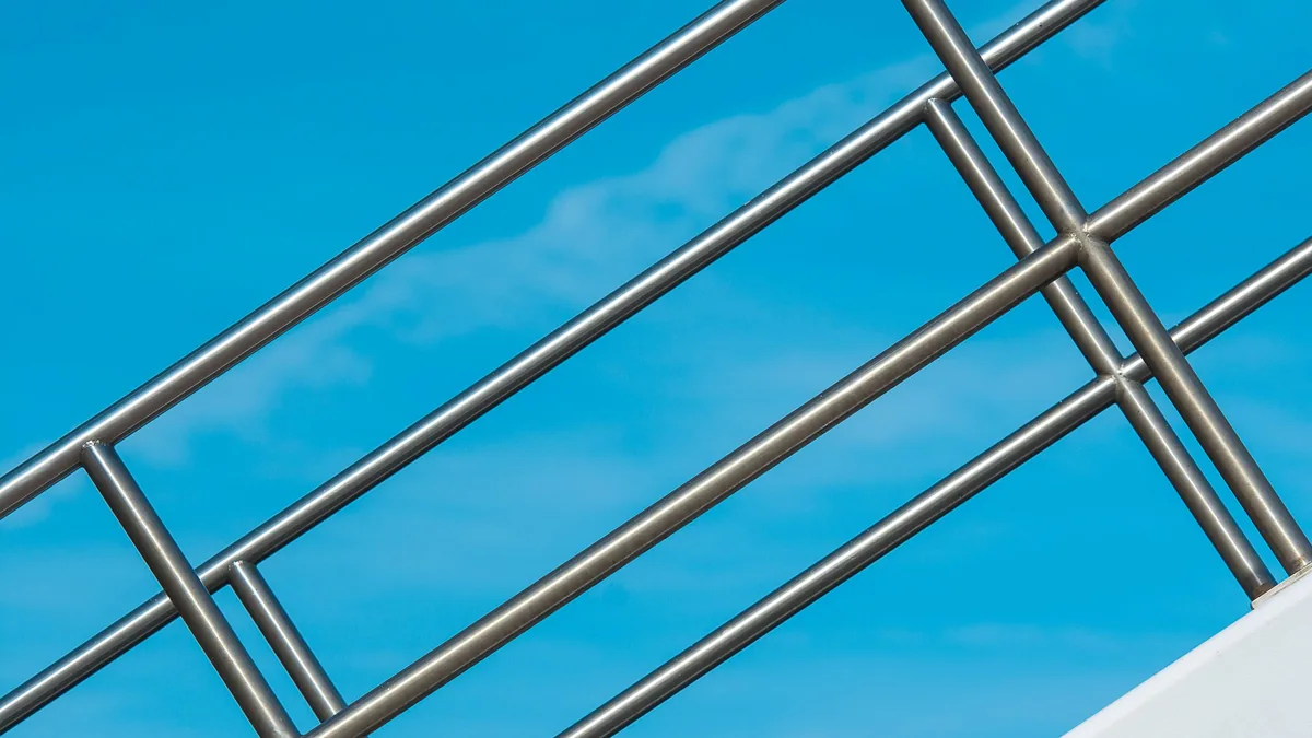 Lisses horizontales inox d'un garde-corps, avec leurs espacements, contre le ciel