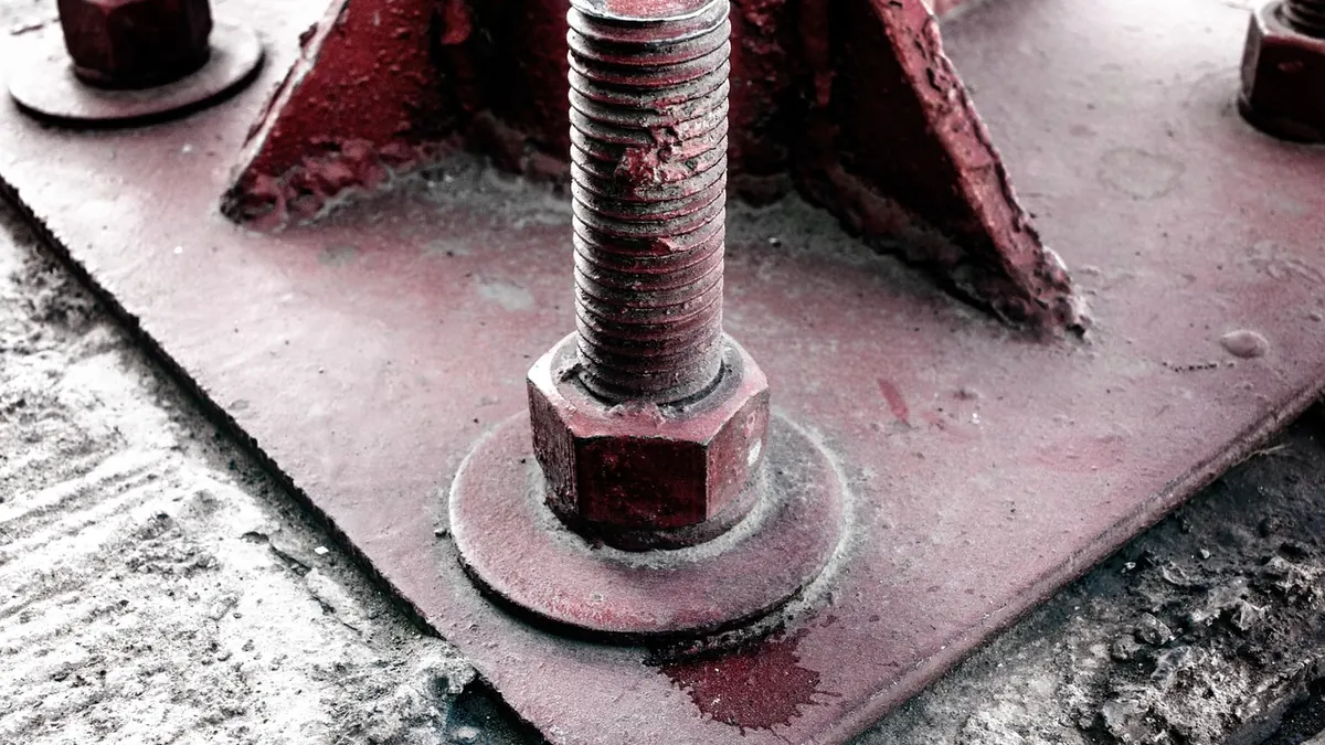 Platine d'ancrage et boulons : la fixation d'un poteau de garde-corps