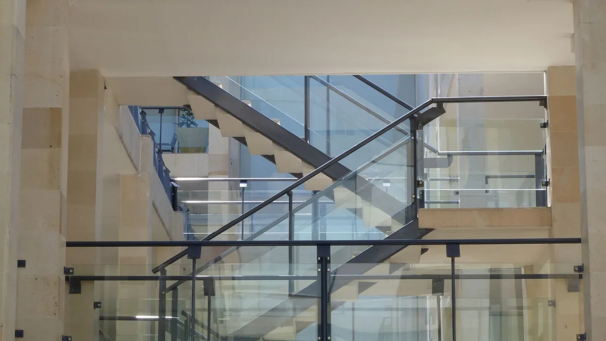 Garde-corps en verre avec cadre : montants et main courante inox sur un escalier
