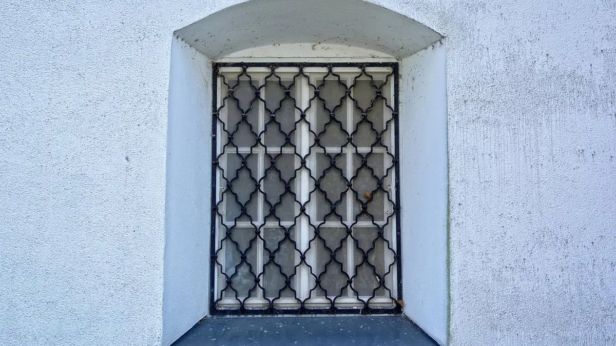Grille de fer posée dans l'embrasure d'une fenêtre, en tableau