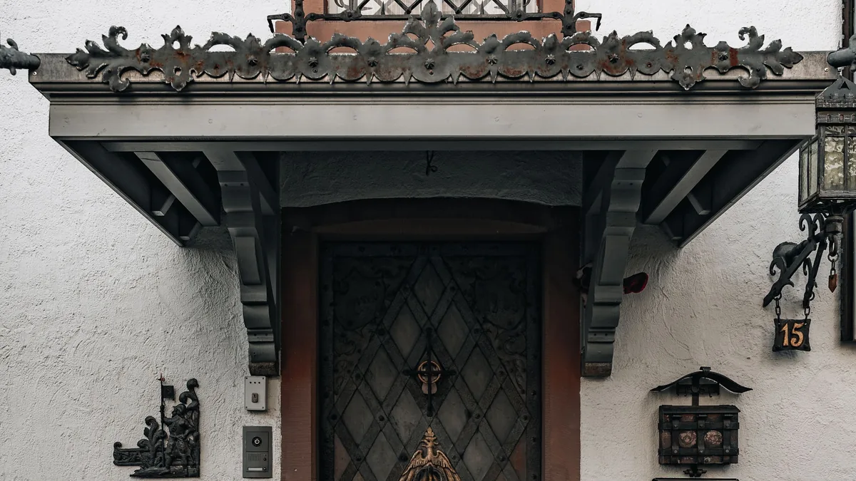 Marquise en fer ouvragé au-dessus d'une porte d'entrée