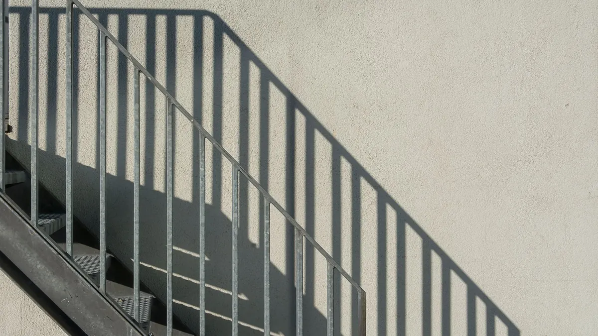 Rampe métallique à barreaux le long d'un escalier extérieur