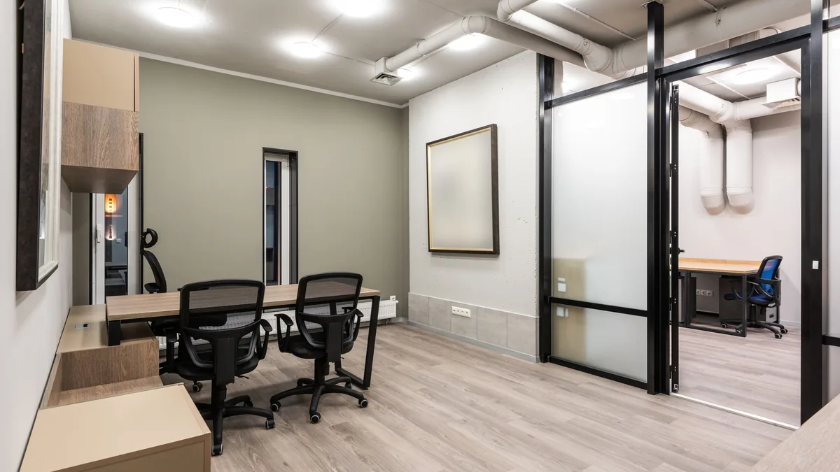 Cloison vitrée à cadre d'acier noir dans un bureau lumineux